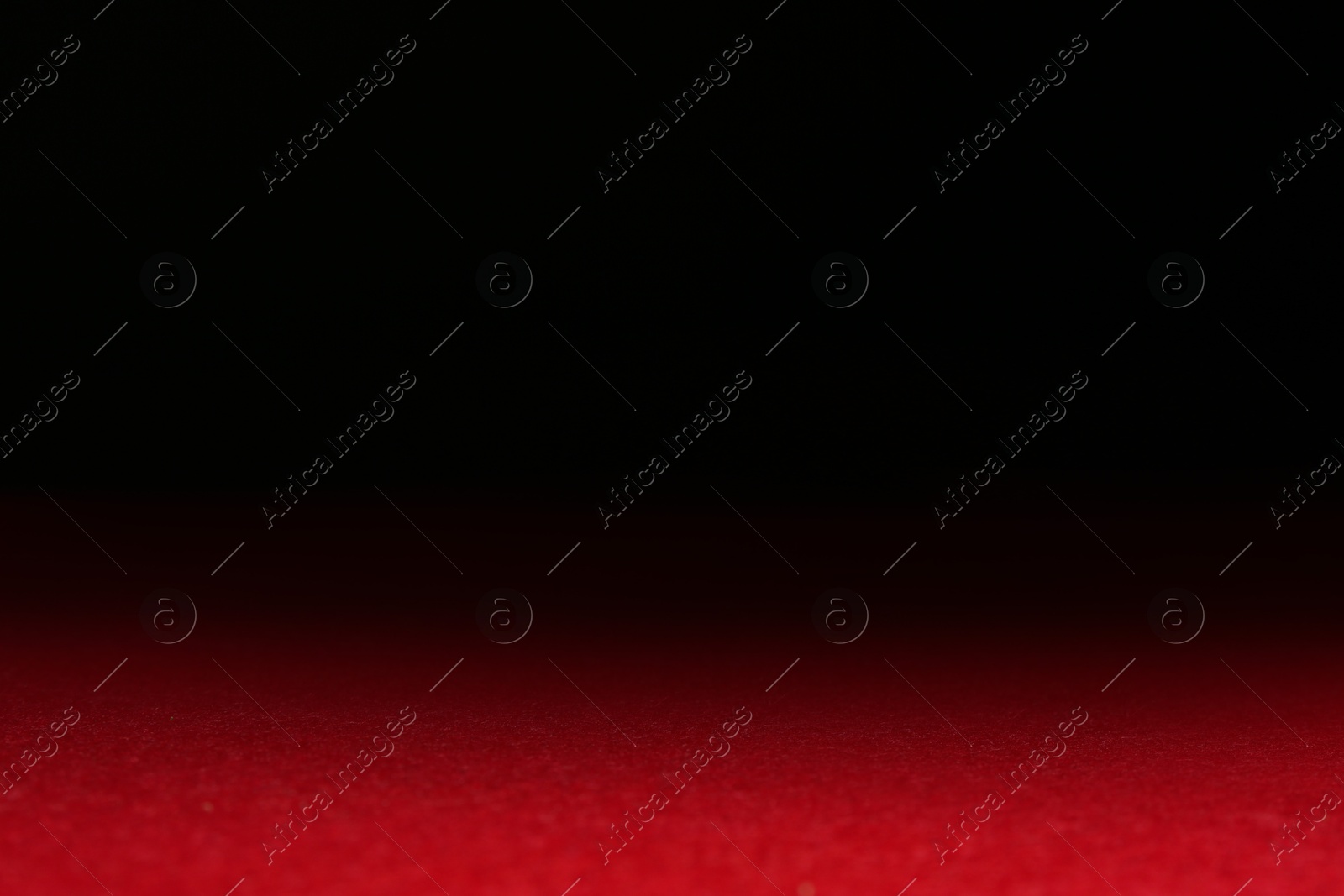 Photo of Red textured surface against dark background, selective focus