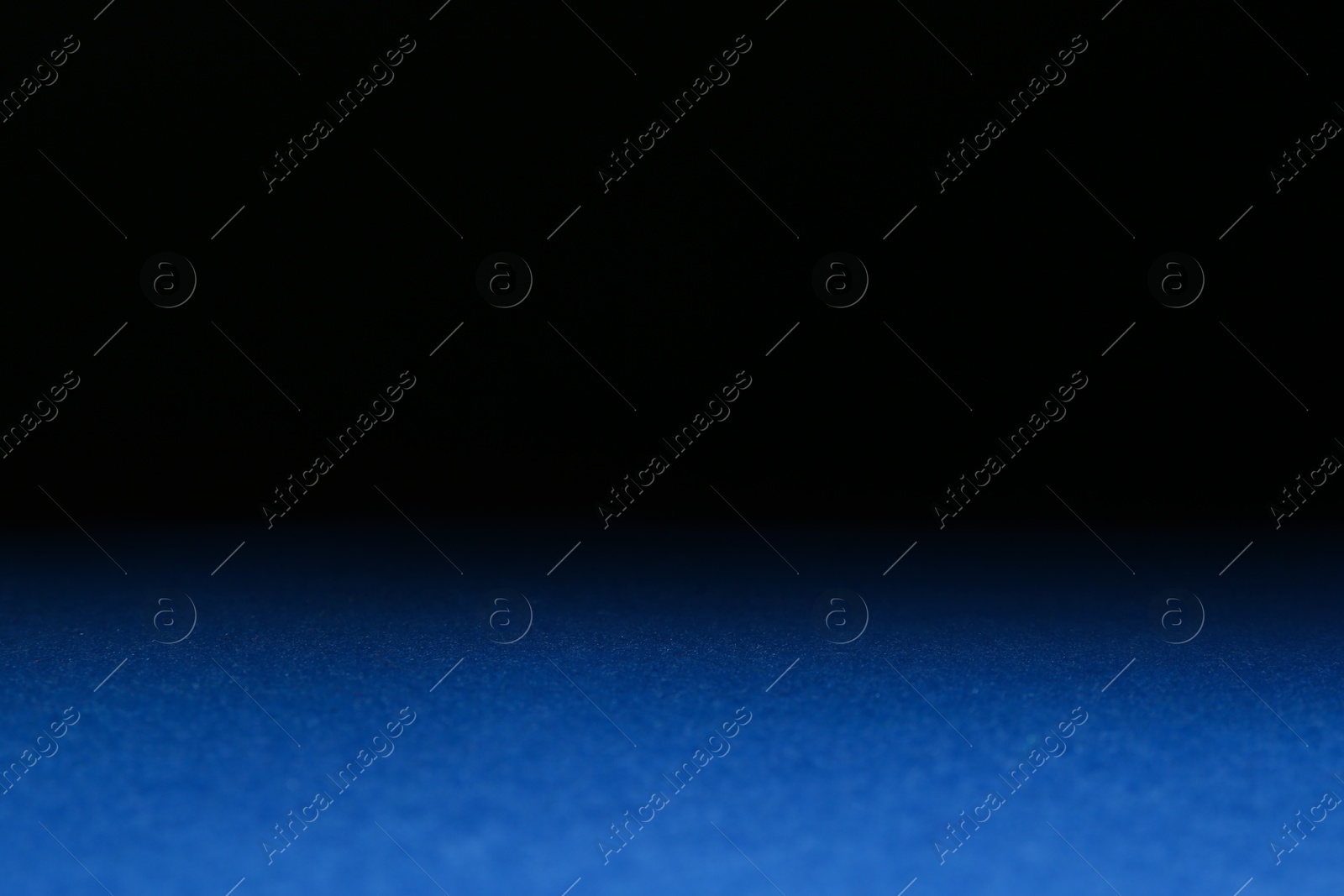 Photo of Blue textured surface against dark background, selective focus