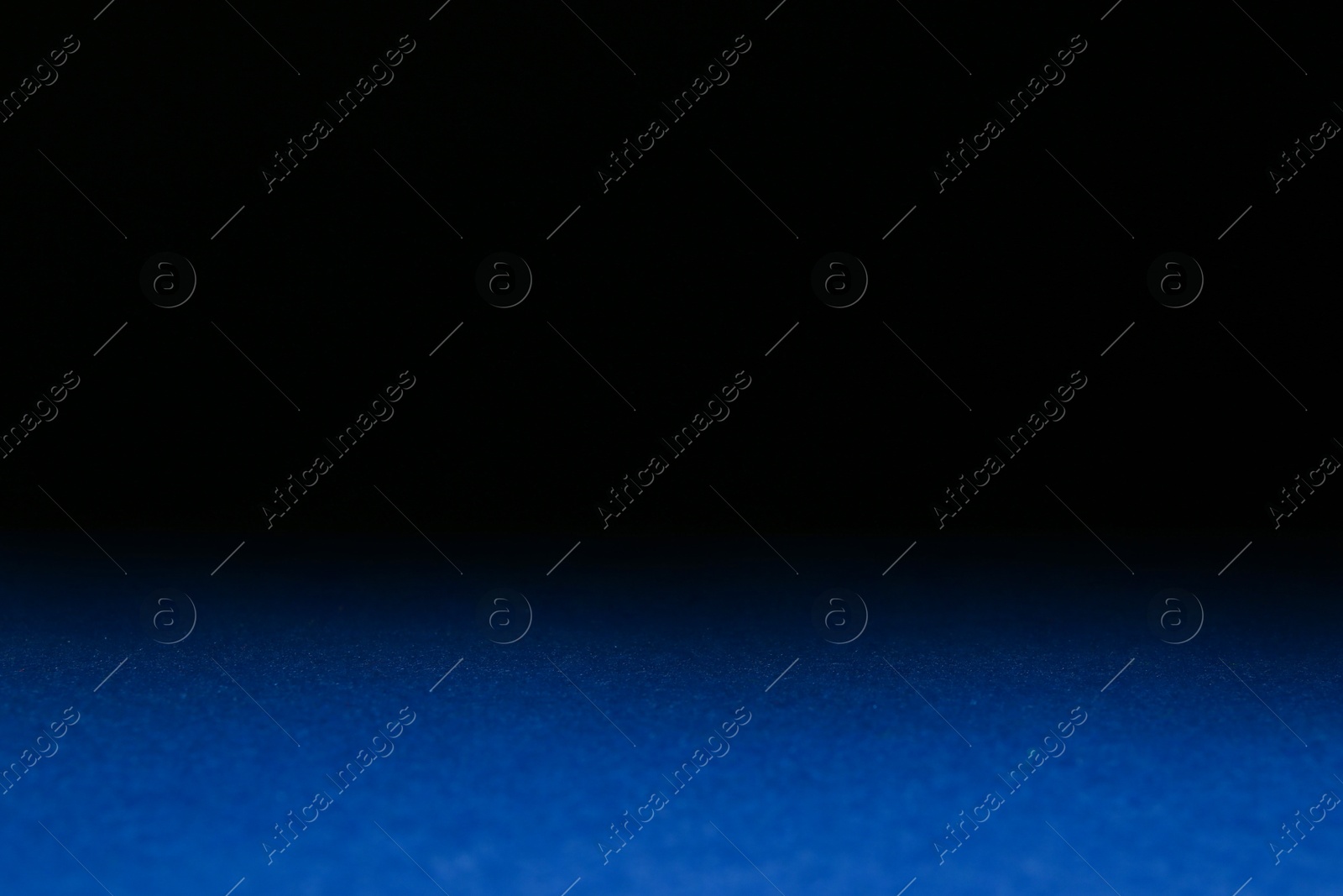 Photo of Blue textured surface against dark background, selective focus