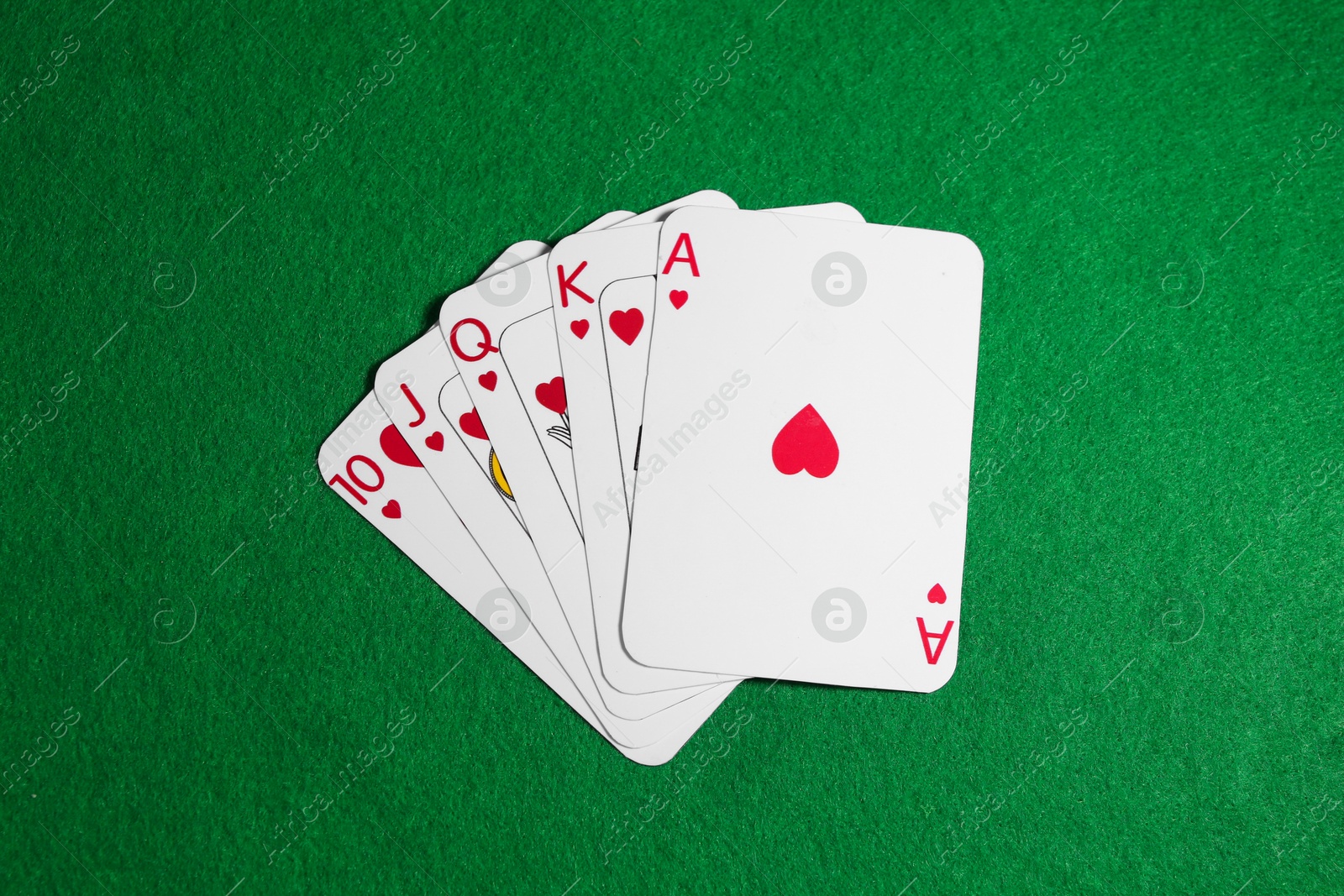 Photo of Poker game. Playing cards on green table, top view