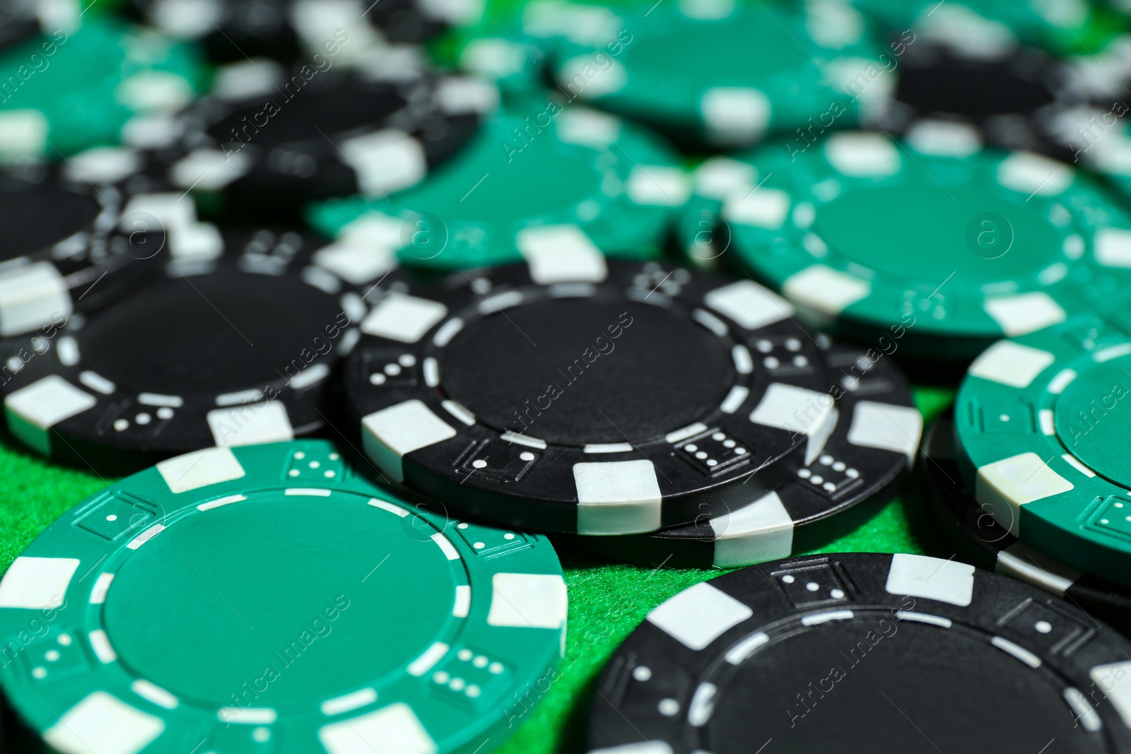 Photo of Poker game. Casino chips on green table, closeup