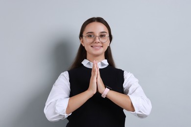 Photo of Young student grateful about her good exam result on grey background