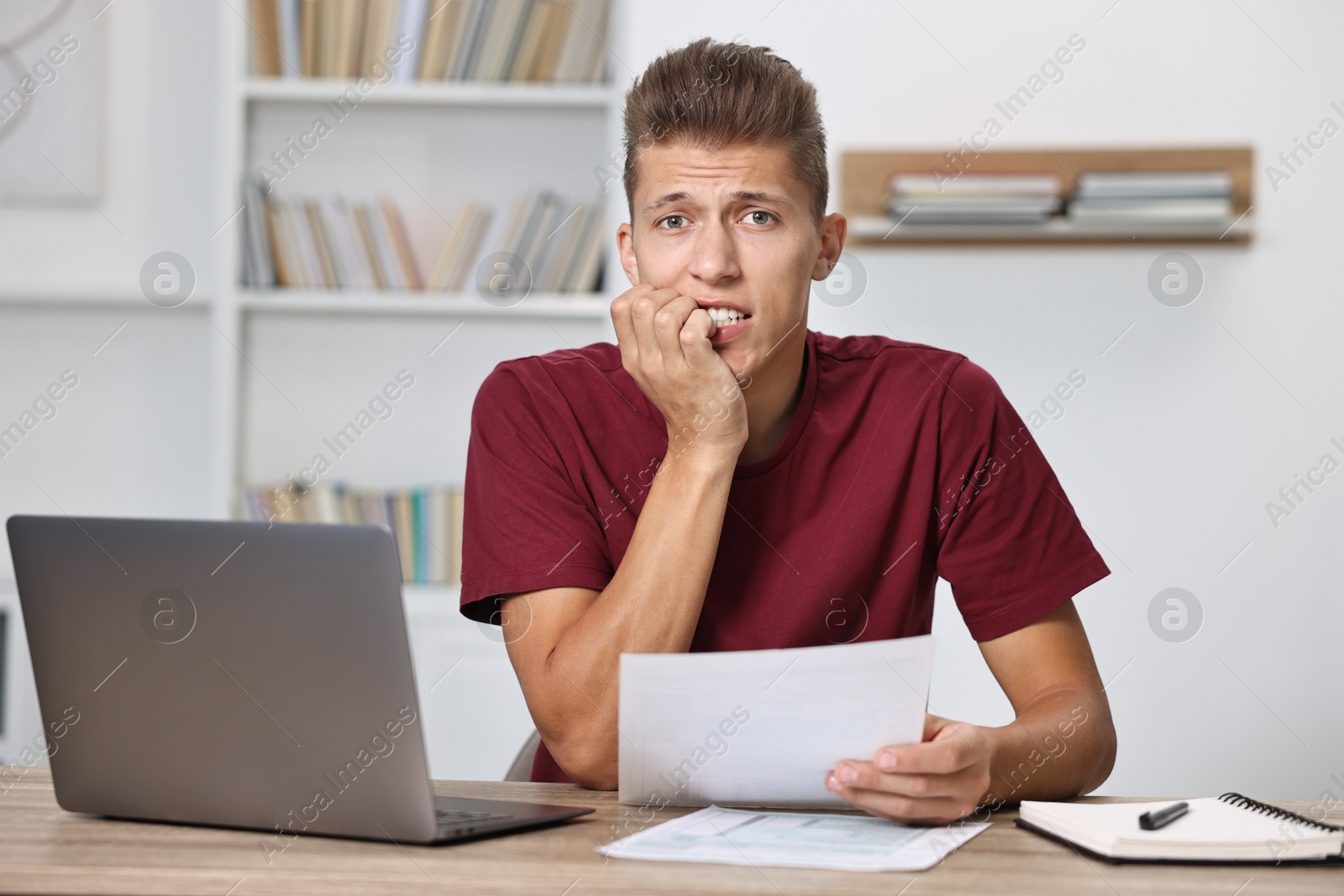 Photo of Tired student having stress before exam at table indoors