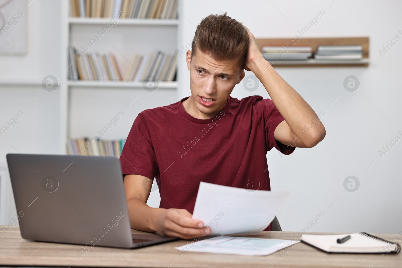 Photo of Tired student having stress before exam at table indoors