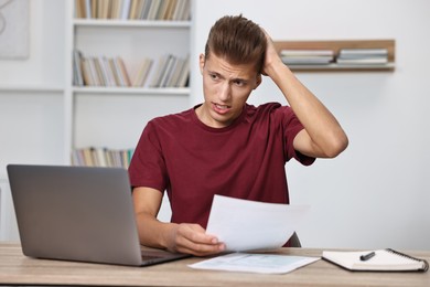 Photo of Tired student having stress before exam at table indoors