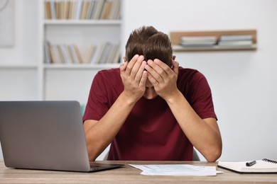 Photo of Tired student having stress before exam at table indoors