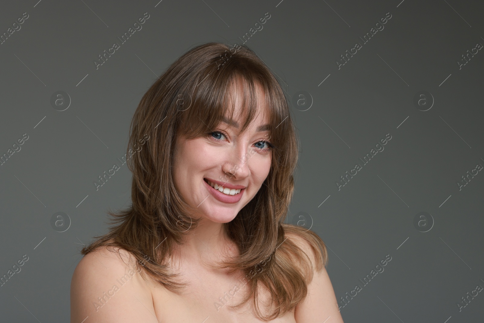 Photo of Attractive woman with stylish haircut on grey background