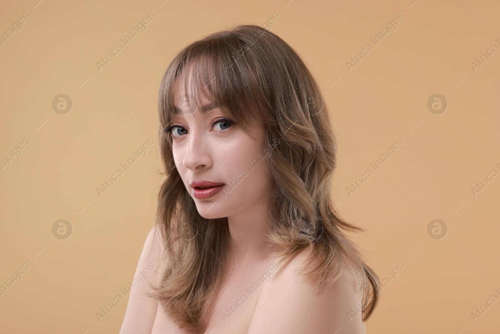 Photo of Attractive woman with stylish haircut on beige background