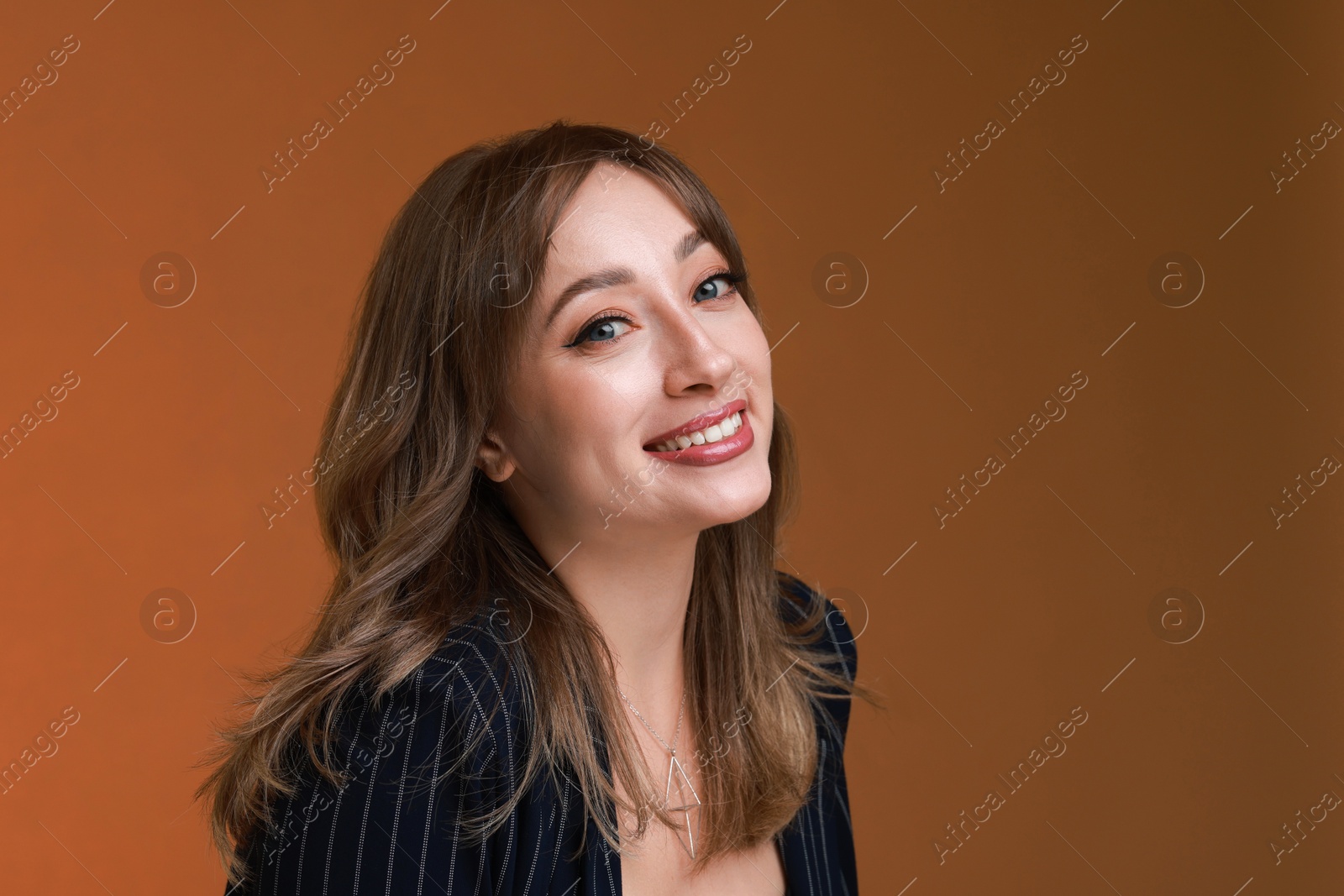 Photo of Attractive woman with stylish haircut on brown background, space for text