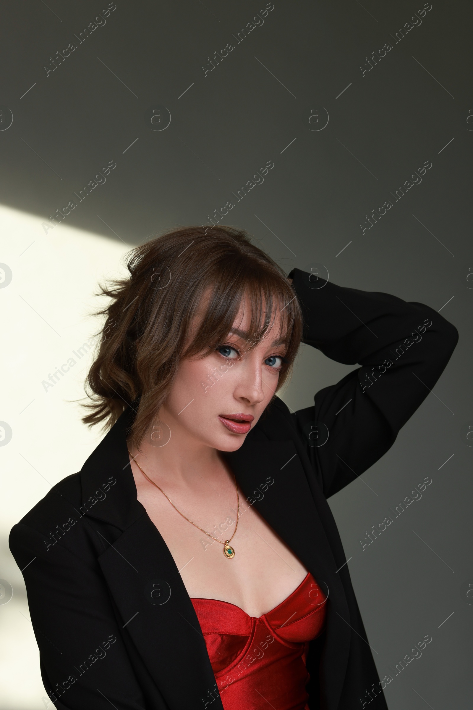 Photo of Attractive woman with stylish haircut against grey wall