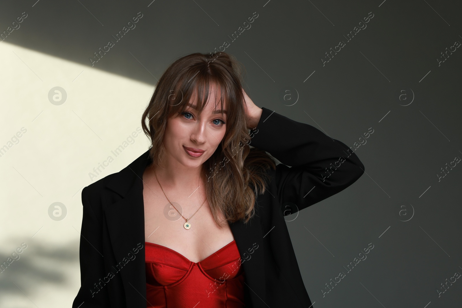 Photo of Attractive woman with stylish haircut against grey wall