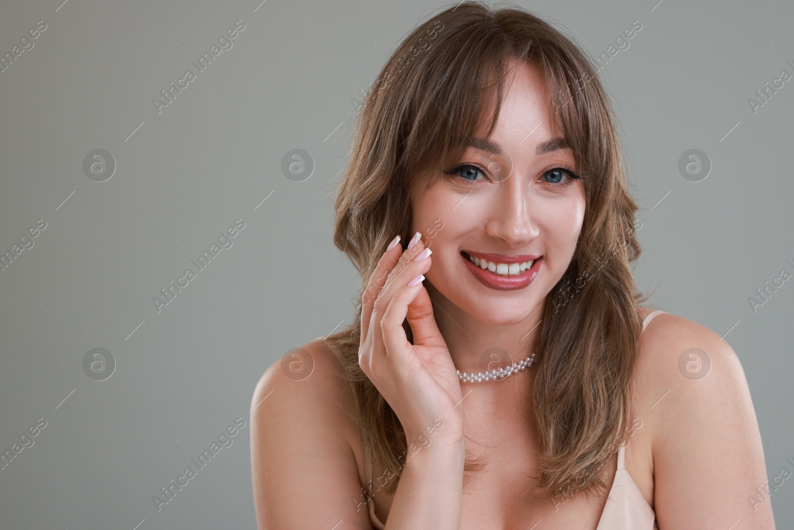 Photo of Attractive woman with stylish haircut on grey background, space for text