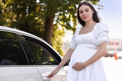 Photo of Portrait of beautiful pregnant woman opening car door outdoors