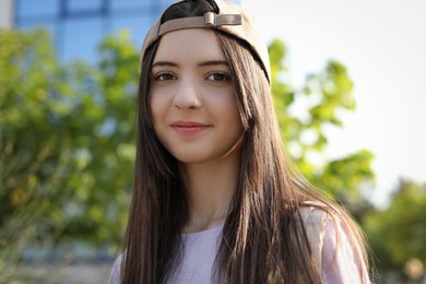 Photo of Portrait of teenage girl in stylish cap outdoors