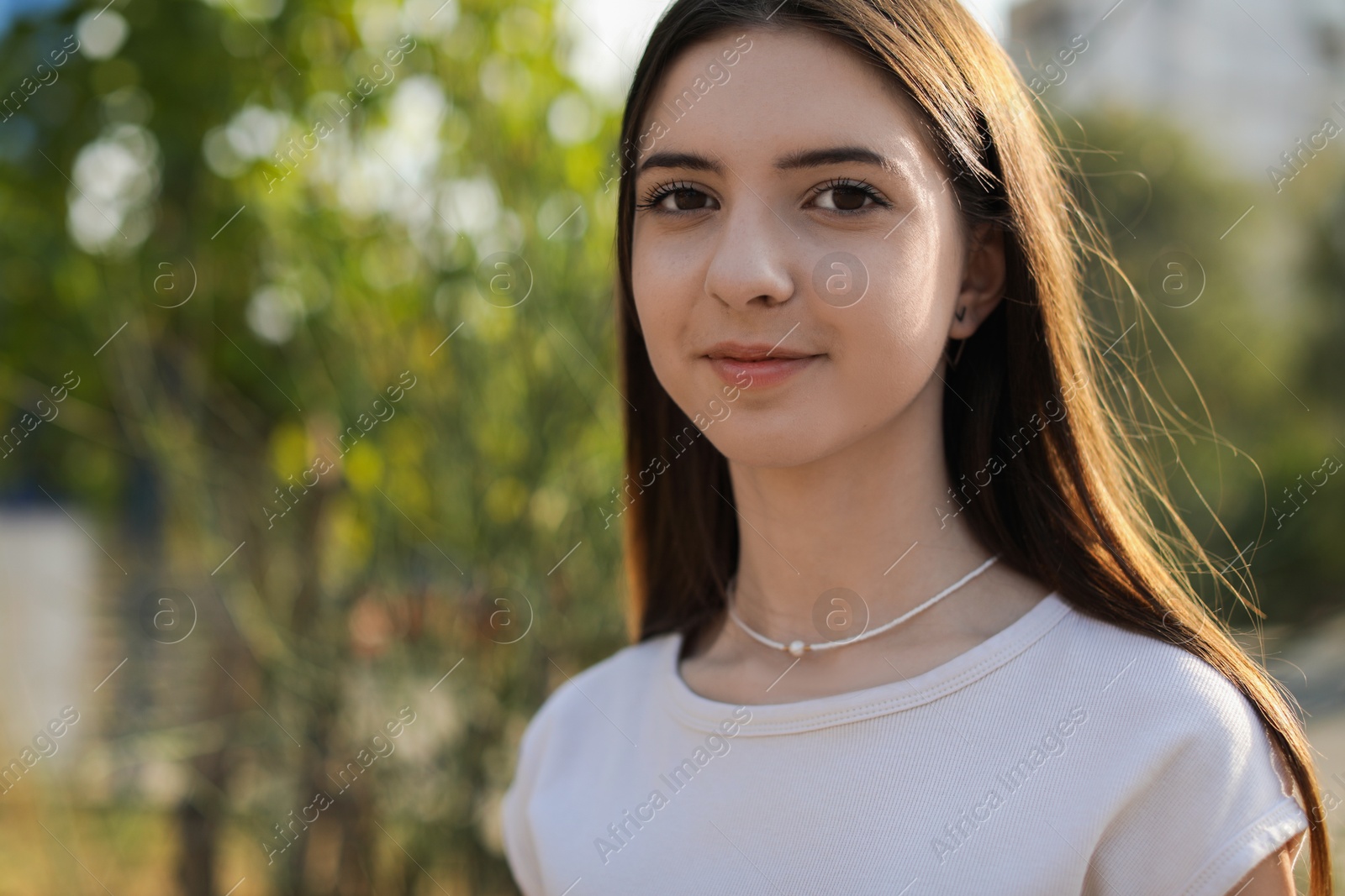 Photo of Portrait of beautiful teenage girl on city street. Space for text