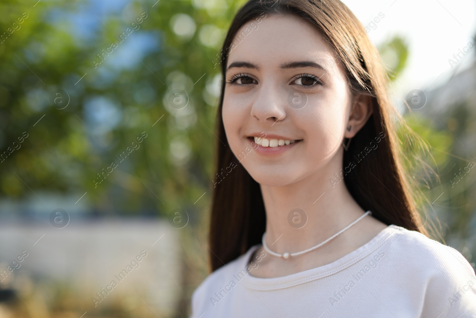 Photo of Portrait of smiling teenage girl outdoors. Space for text