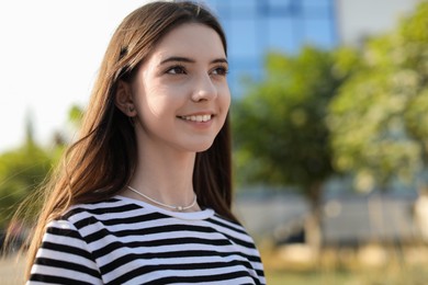 Photo of Portrait of smiling teenage girl outdoors. Space for text