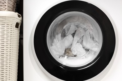 Photo of Washing machine with clothes as background, closeup