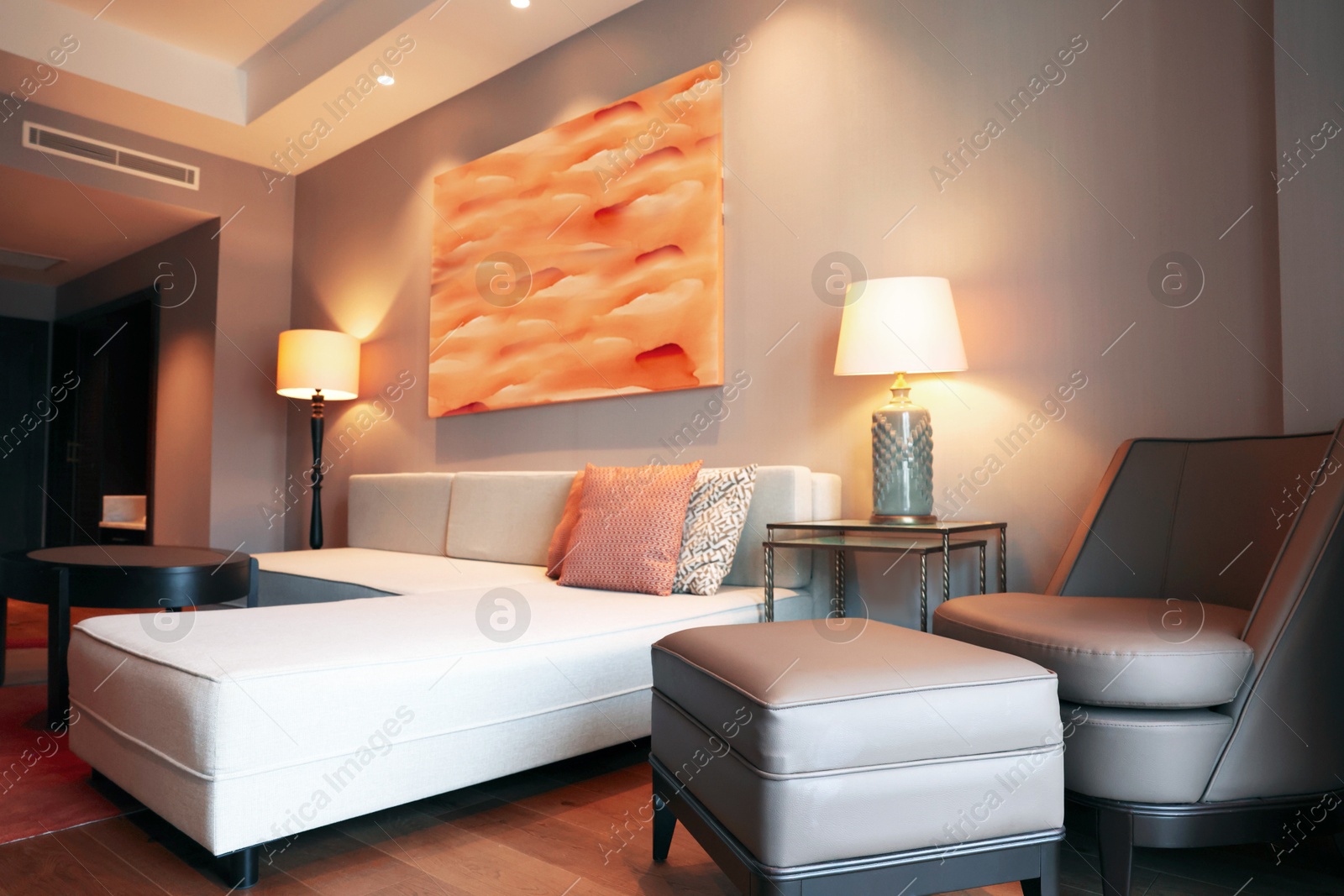 Photo of Comfortable furniture and beautiful abstract painting on wall in room