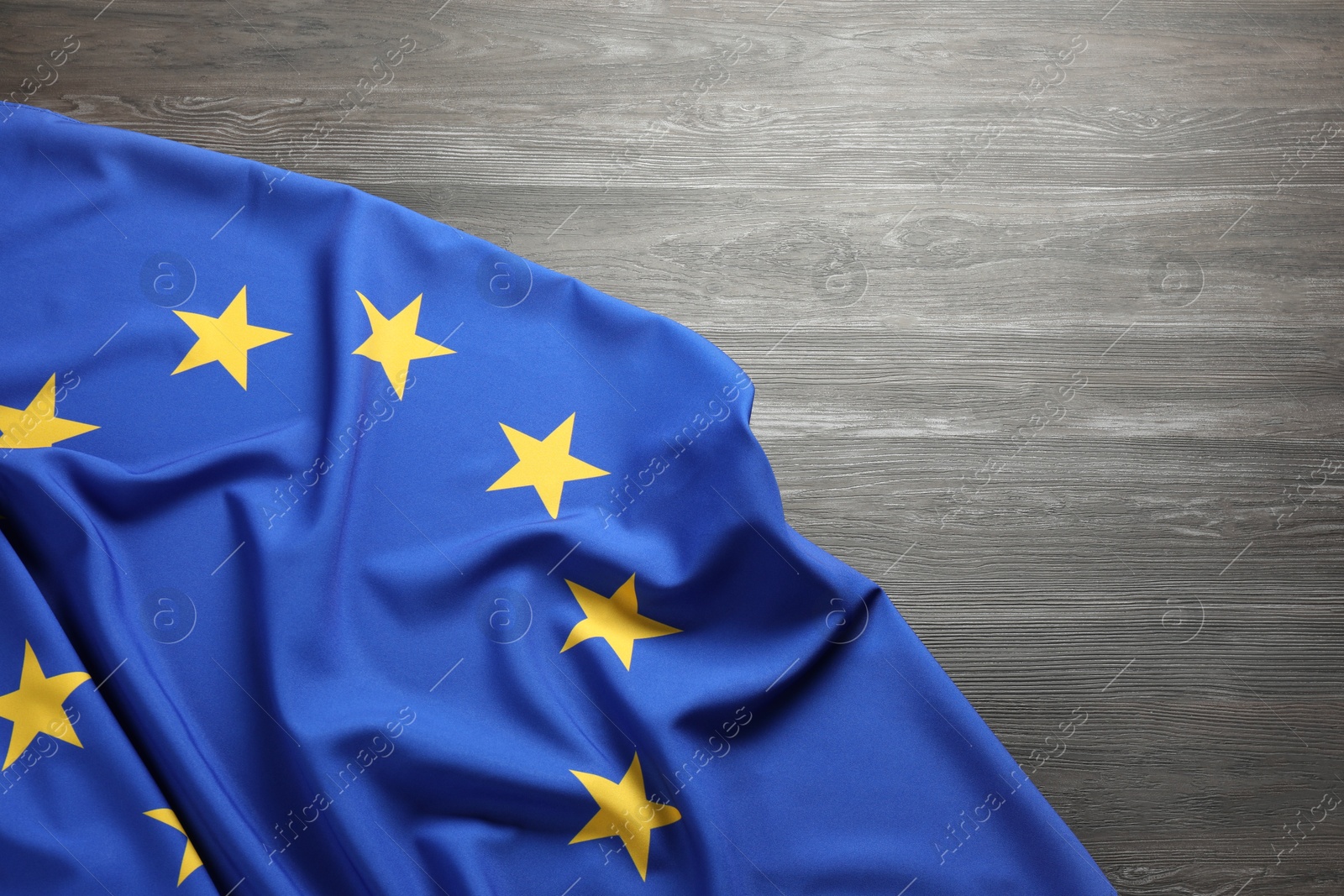 Photo of Flag of European Union on wooden background, top view. Space for text