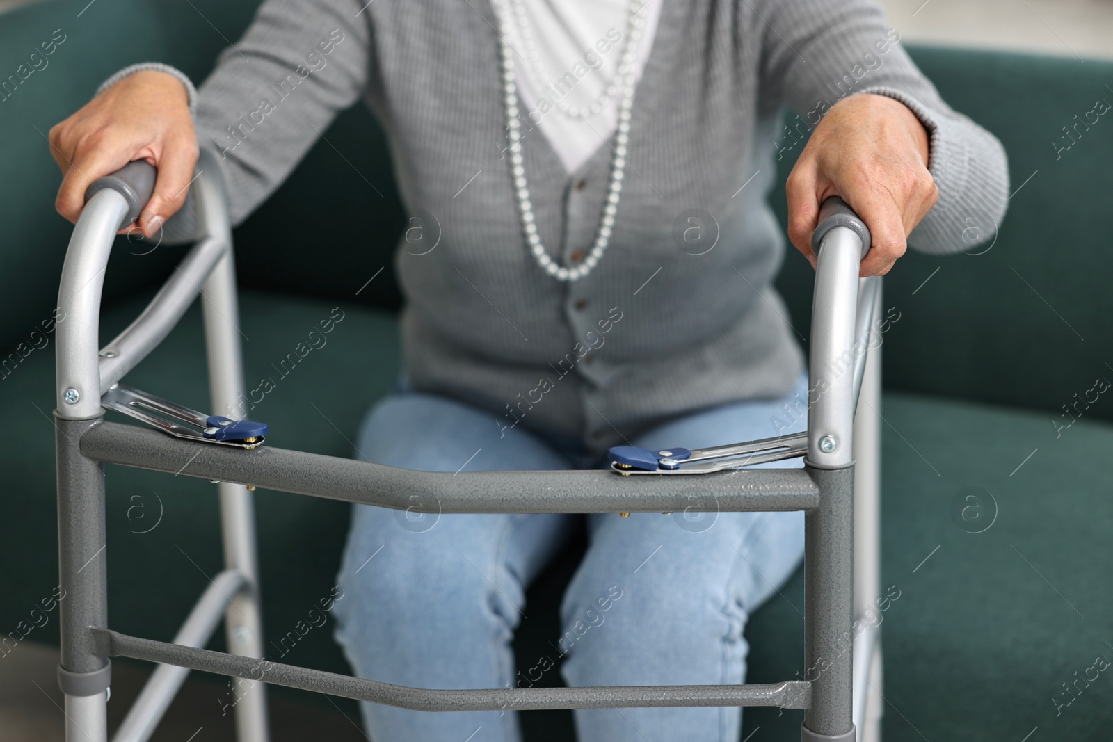 Photo of Senior woman with walking frame on sofa at home, closeup