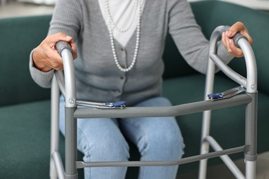 Photo of Senior woman with walking frame on sofa at home, closeup