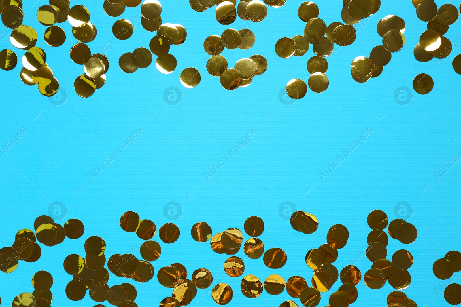 Photo of Shiny confetti on light blue background, top view. Space for text