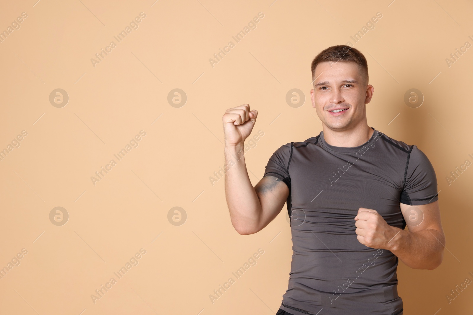 Photo of Portrait of happy winner on beige background, space for text