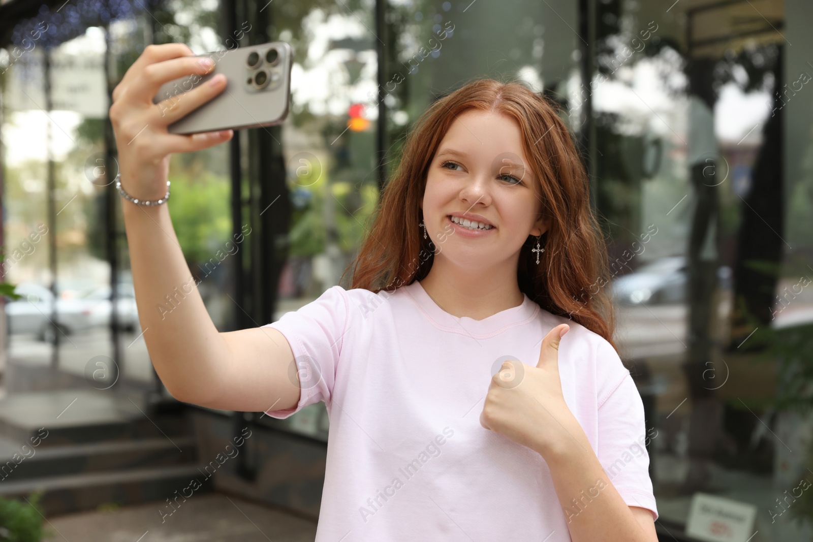 Photo of Beautiful teenage girl taking selfie with smartphone outdoors