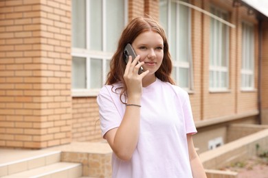 Photo of Beautiful teenage girl talking on phone outdoors