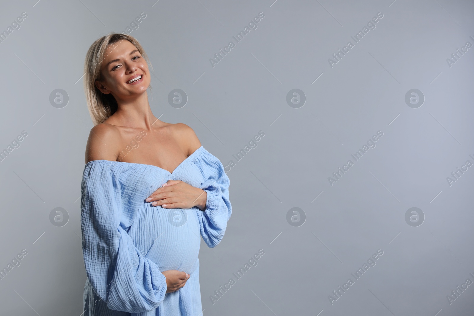 Photo of Portrait of beautiful pregnant woman on grey background, space for text