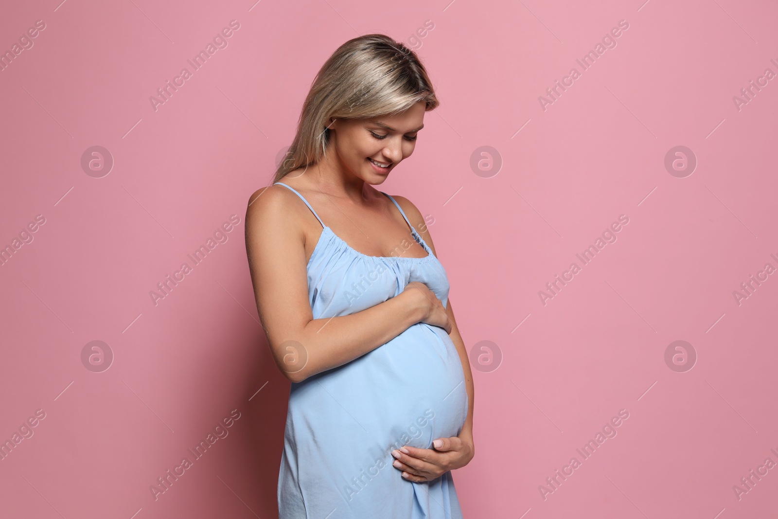 Photo of Portrait of beautiful pregnant woman on pink background