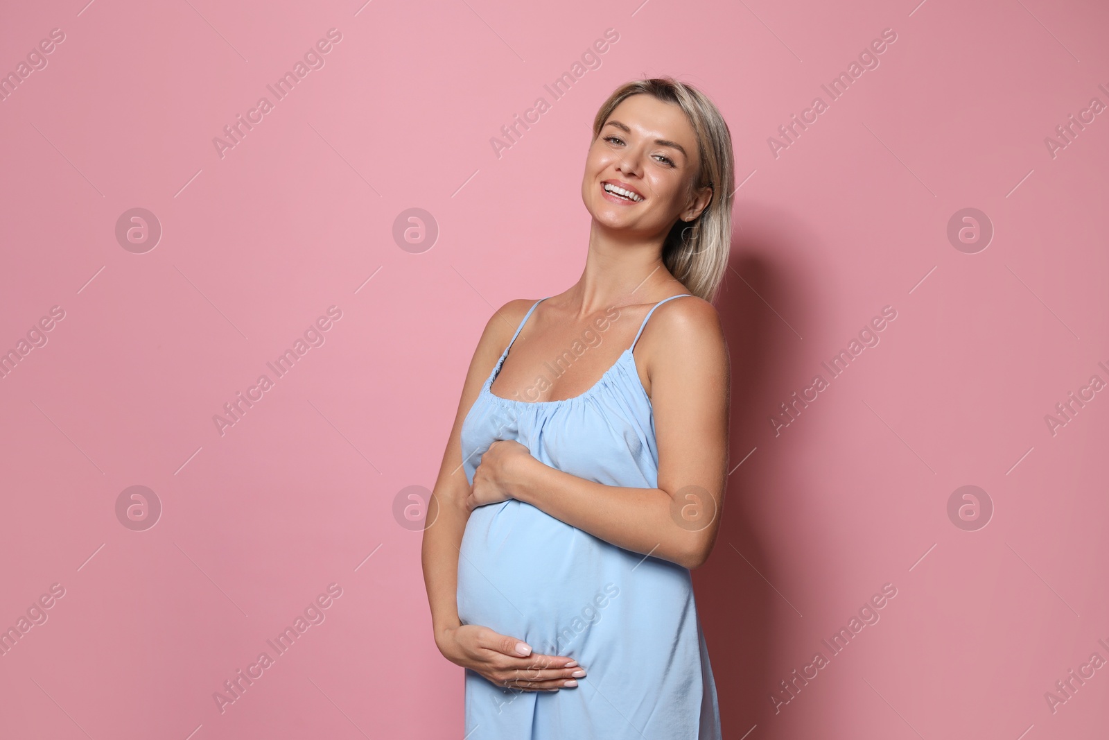 Photo of Portrait of beautiful pregnant woman on pink background