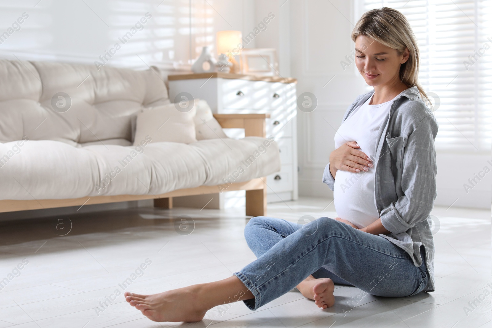 Photo of Portrait of beautiful pregnant woman on floor at home