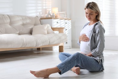 Photo of Portrait of beautiful pregnant woman on floor at home