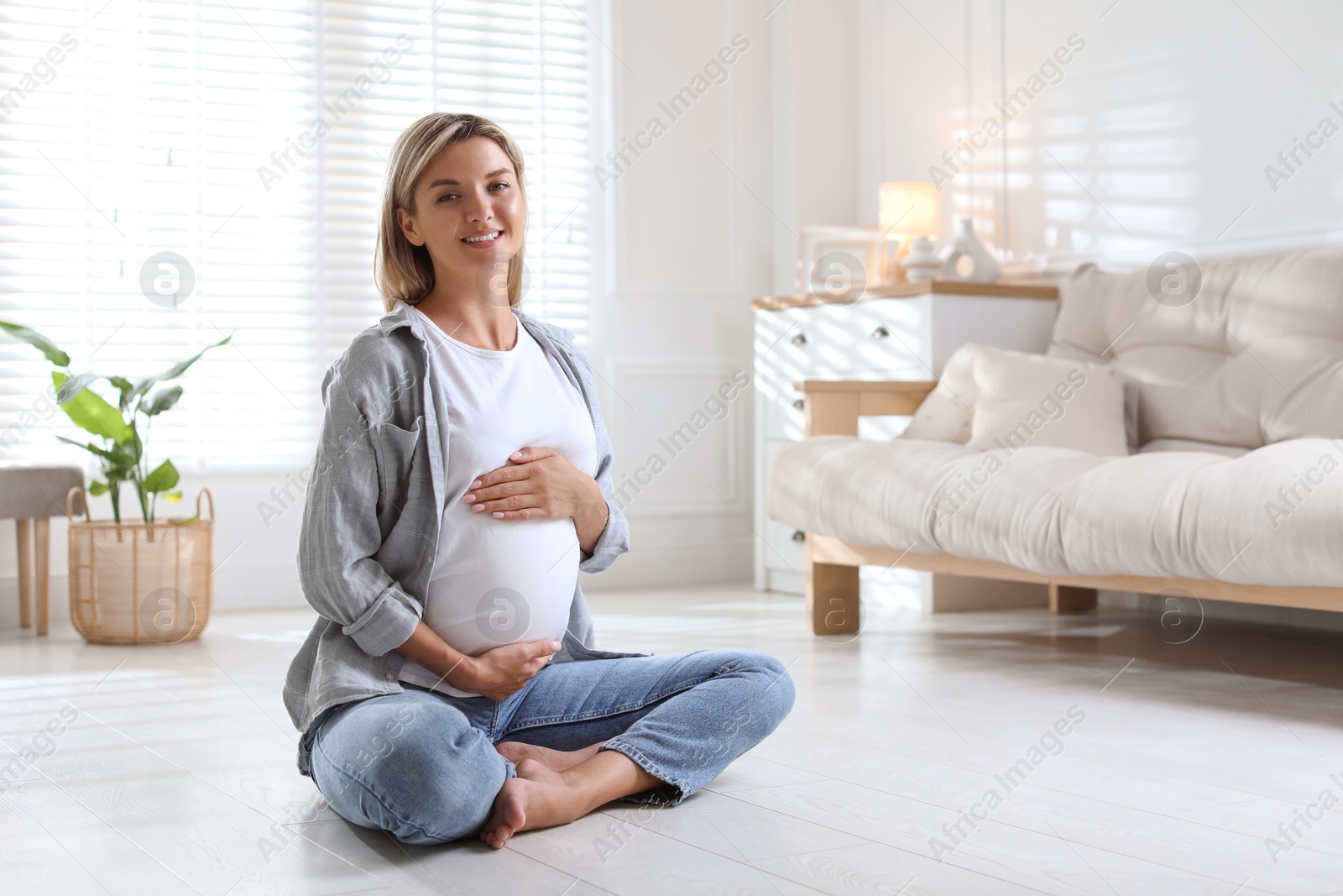 Photo of Portrait of beautiful pregnant woman on floor at home