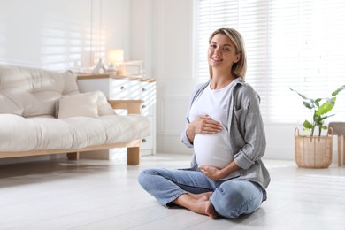 Photo of Portrait of beautiful pregnant woman on floor at home