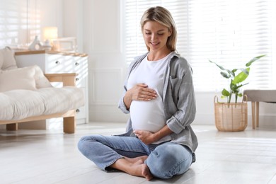 Portrait of beautiful pregnant woman on floor at home