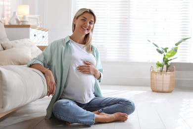 Photo of Portrait of beautiful pregnant woman on floor at home