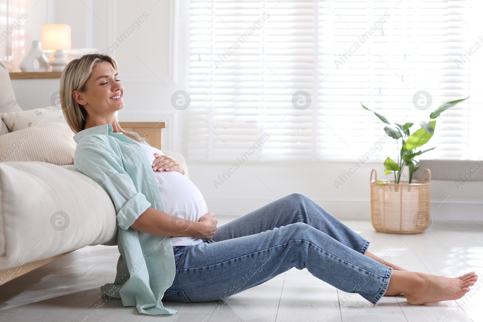 Photo of Portrait of beautiful pregnant woman on floor at home