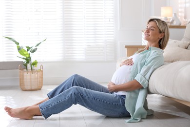 Photo of Portrait of beautiful pregnant woman on floor at home