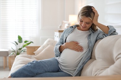 Photo of Portrait of beautiful pregnant woman on sofa at home