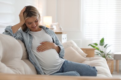 Photo of Portrait of beautiful pregnant woman on sofa at home