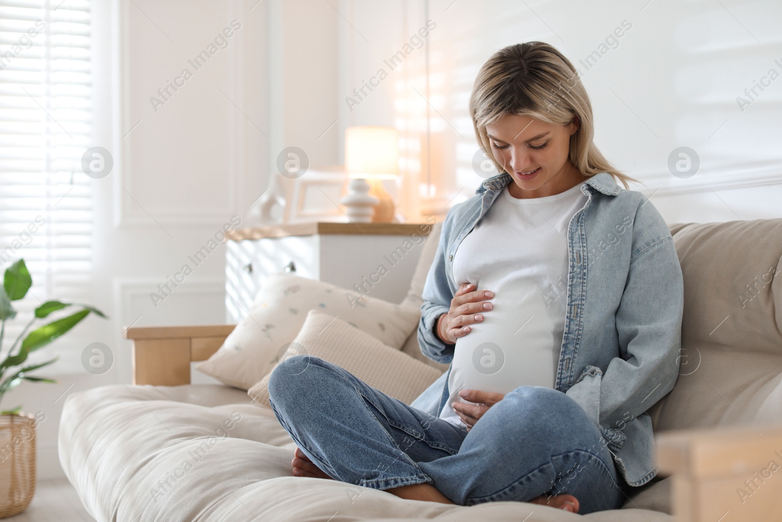 Photo of Portrait of beautiful pregnant woman on sofa at home