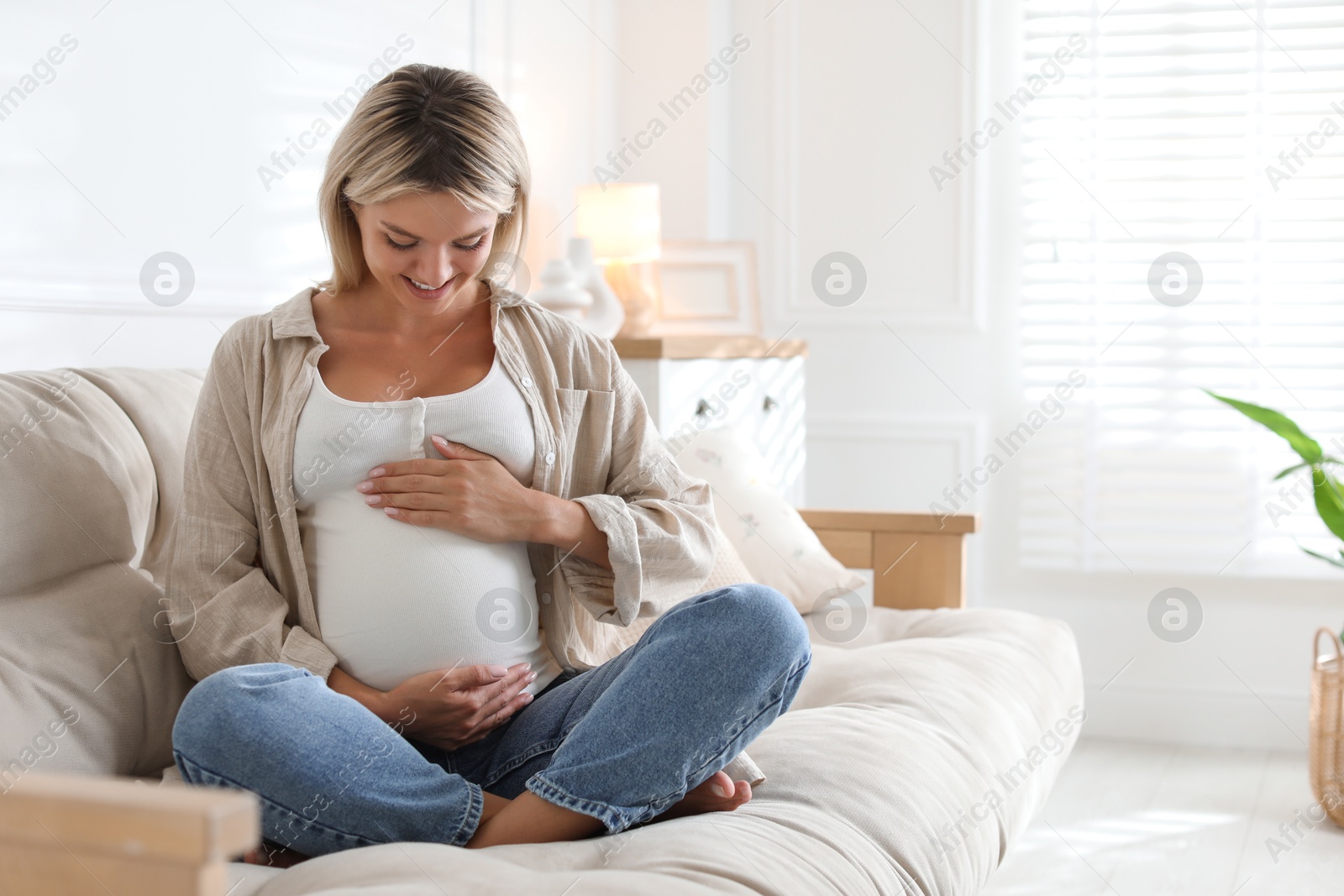 Photo of Portrait of beautiful pregnant woman on sofa at home