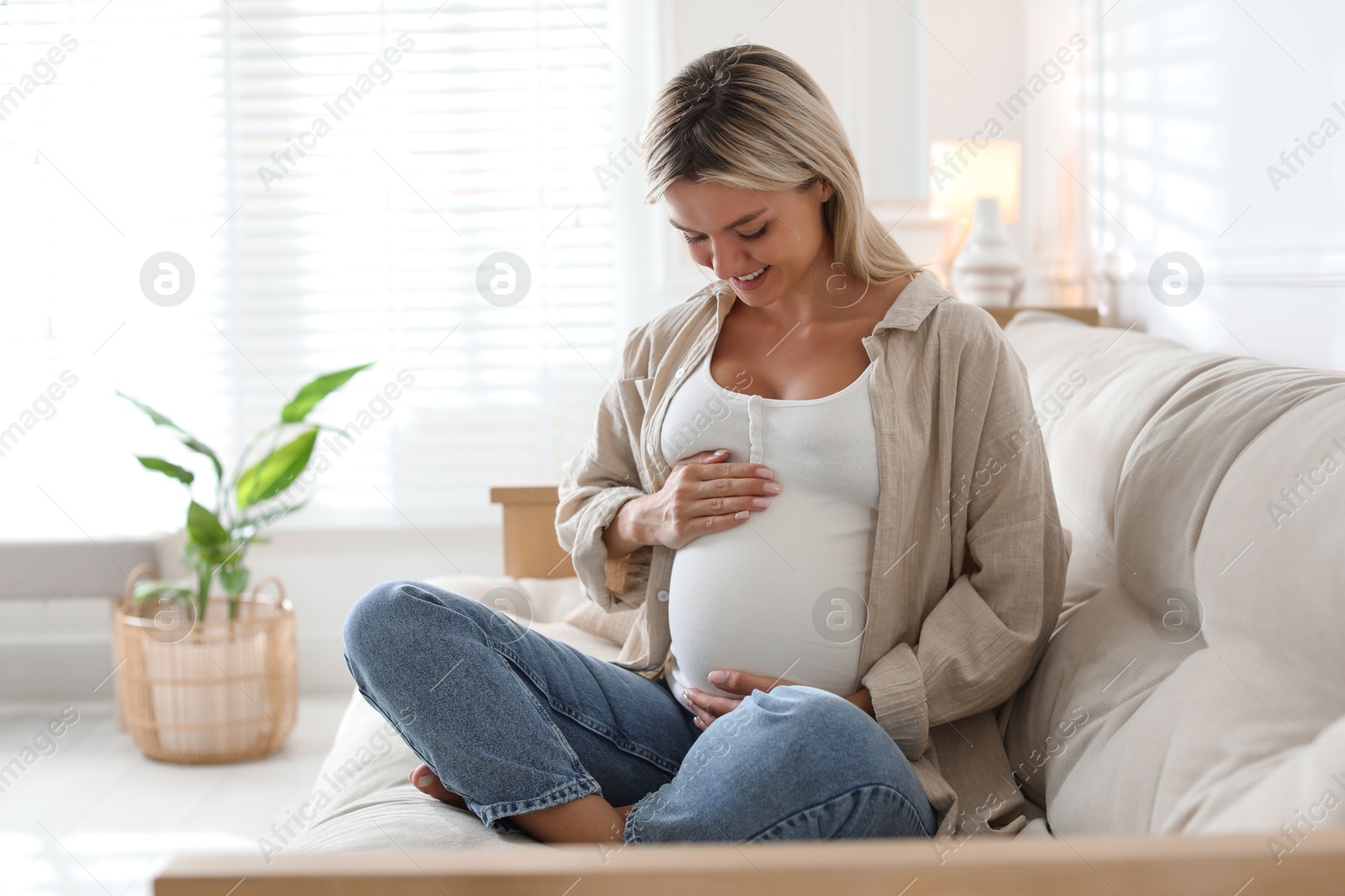 Photo of Portrait of beautiful pregnant woman on sofa at home