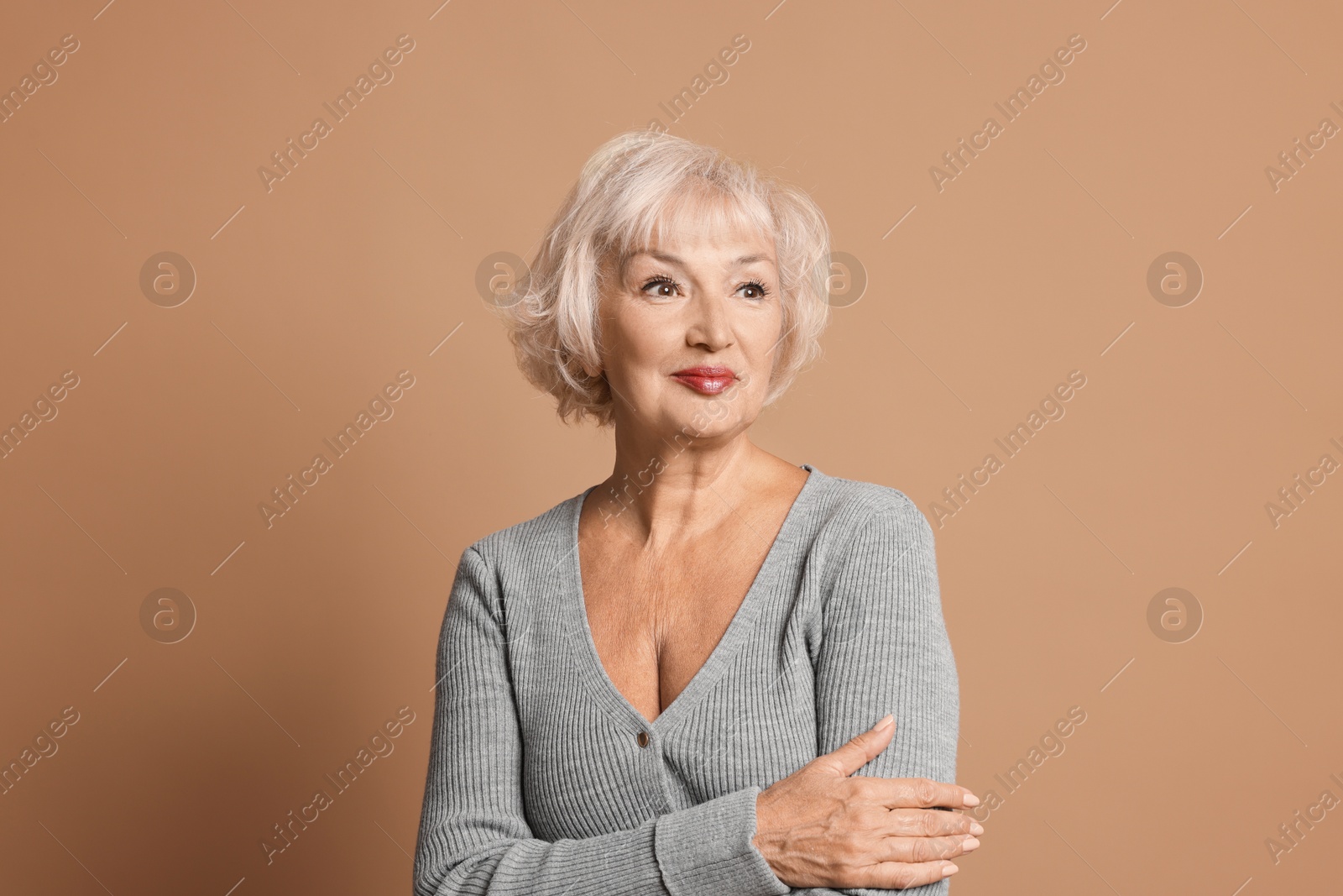 Photo of Portrait of beautiful senior woman on light brown background