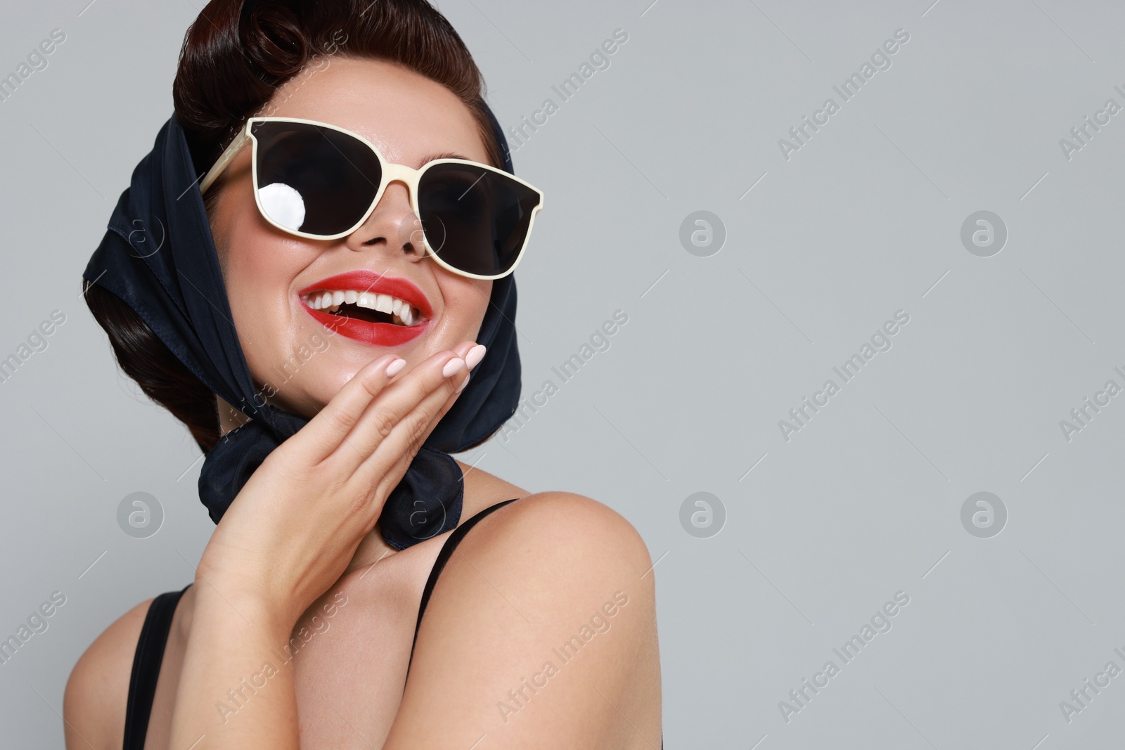 Photo of Pin-up woman in sunglasses on grey background, space for text