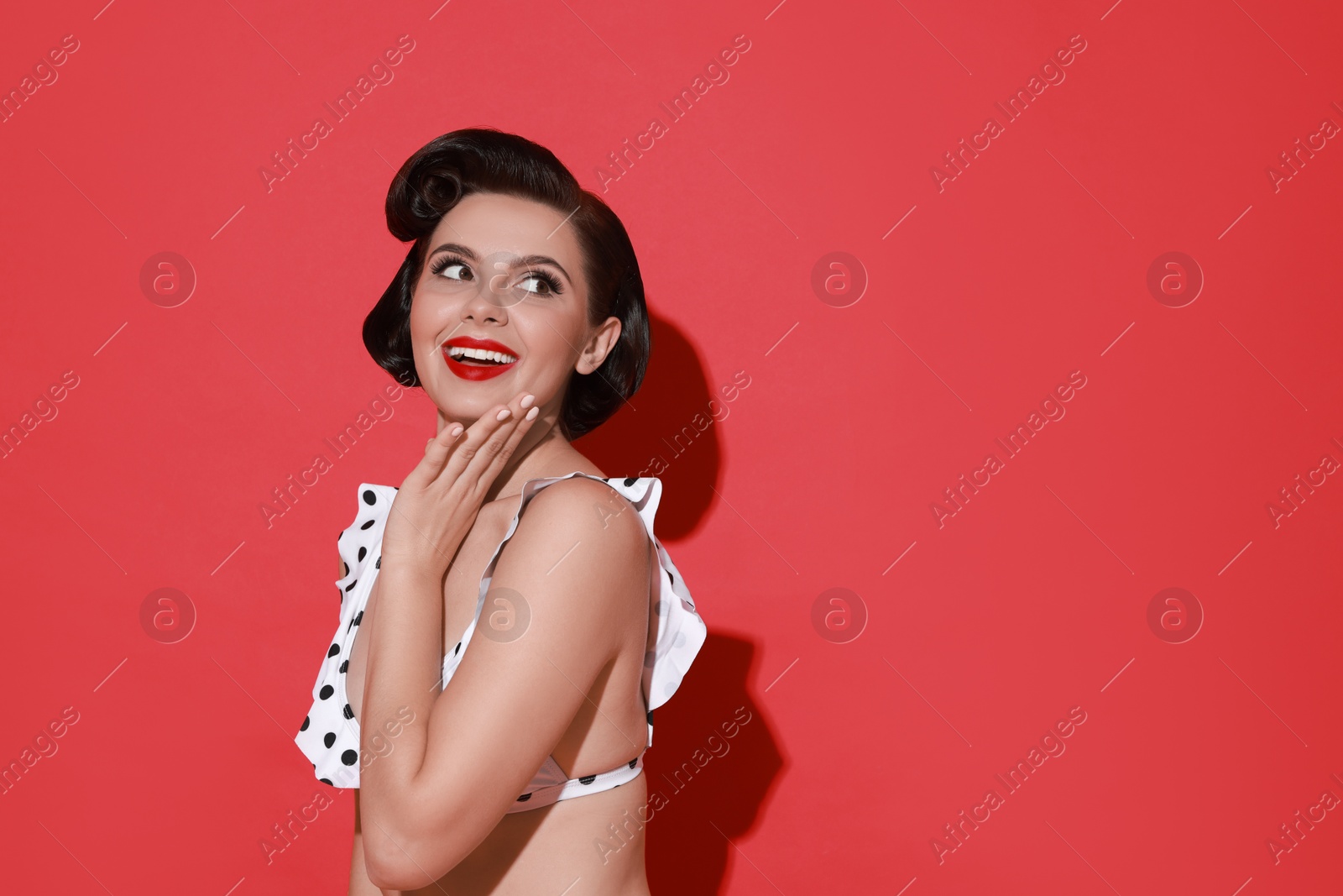 Photo of Pin-up woman in bikini on red background, space for text