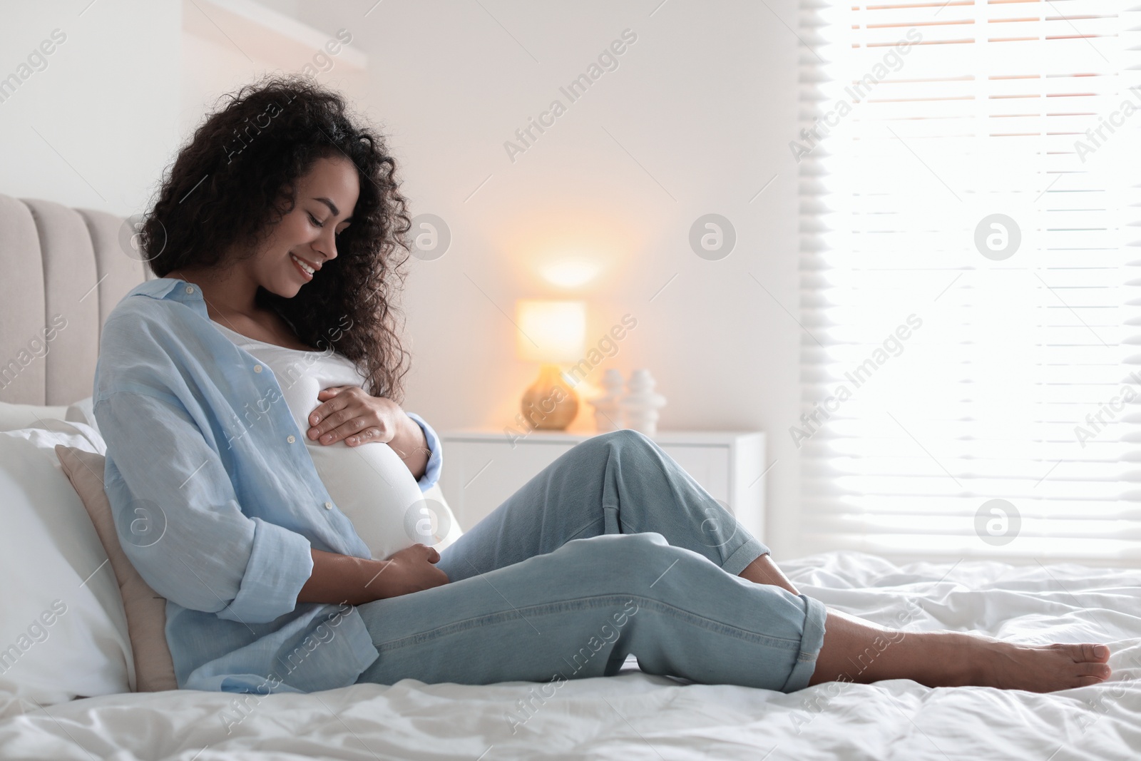 Photo of Portrait of beautiful pregnant woman on bed at home